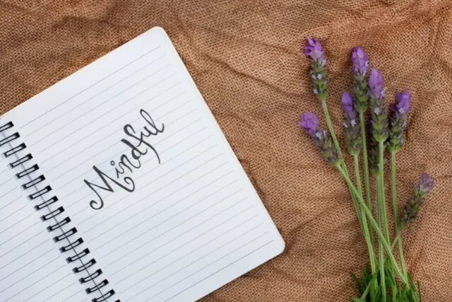 ノートにMindfulと書かれたページとラベンダーの花