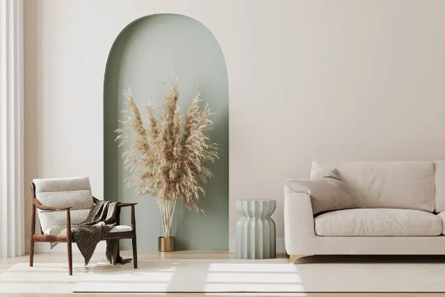 柔らかな光が差し込むリビング。ベージュのソファとグリーンの植物が調和する穏やかな空間。