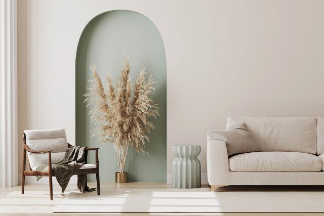 柔らかな光が差し込むリビング。ベージュのソファとグリーンの植物が調和する穏やかな空間。