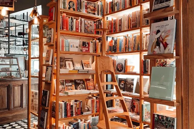 カフェ併設の書店。木の本棚に囲まれ、あたたかな光が差し込む落ち着いた空間