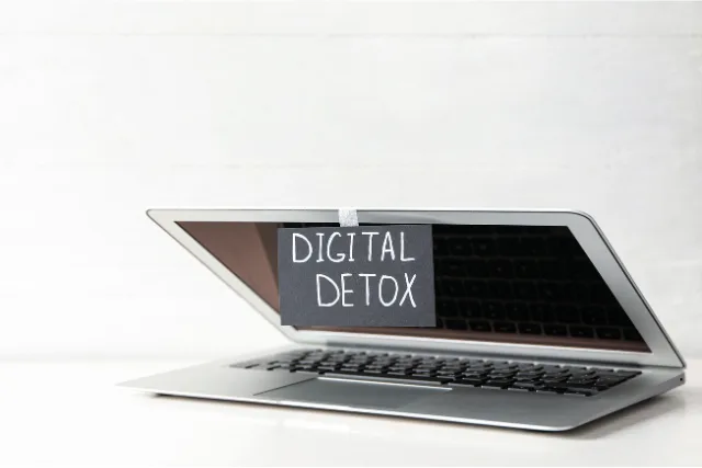 ノートパソコンの画面を閉じ、「DIGITAL DETOX」と書かれた紙が貼られている様子