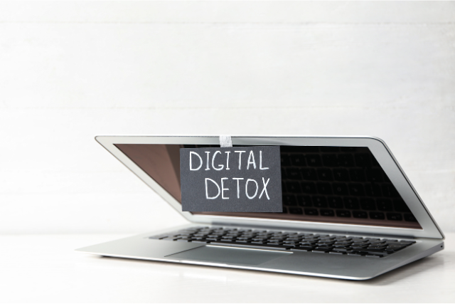 ノートパソコンの画面を閉じ、「DIGITAL DETOX」と書かれた紙が貼られている様子