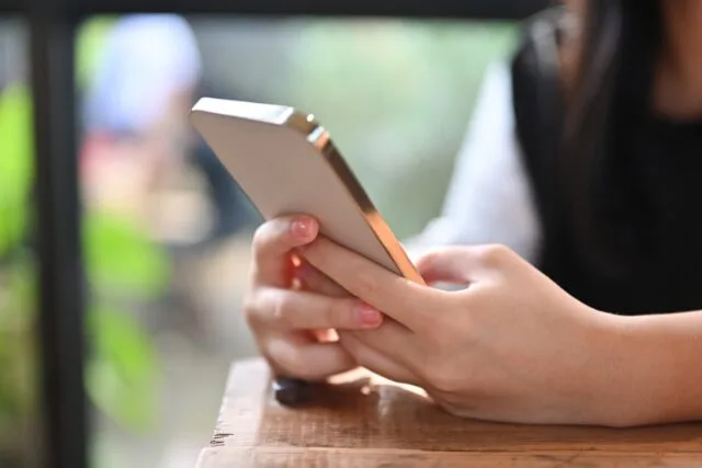 スマホを持つ女性の手の写真