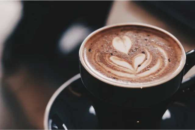 ハートのラテアートが浮かんでいるコーヒーカップ